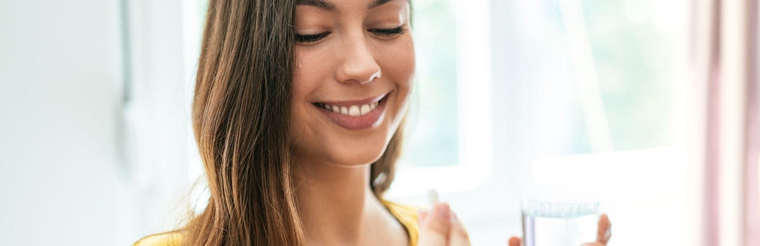 An image of a woman taking a supplement.
